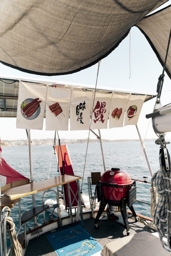 Barbacoa tipo kamado roja instalada en la cubierta de un velero