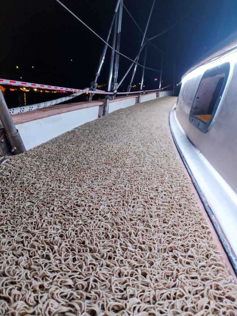 Cubierta antideslizante junto a la borda de un velero de noche