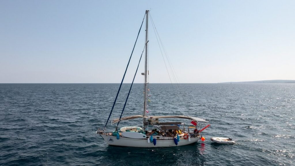 Velero fondeado en mar abierto con el horizonte de fondo